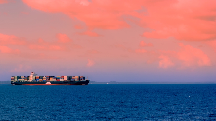 Ett containerfartyg i solnedgång.